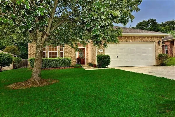 a front view of a house with a garden and yard