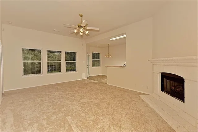 a view of an empty room with a fireplace and a window