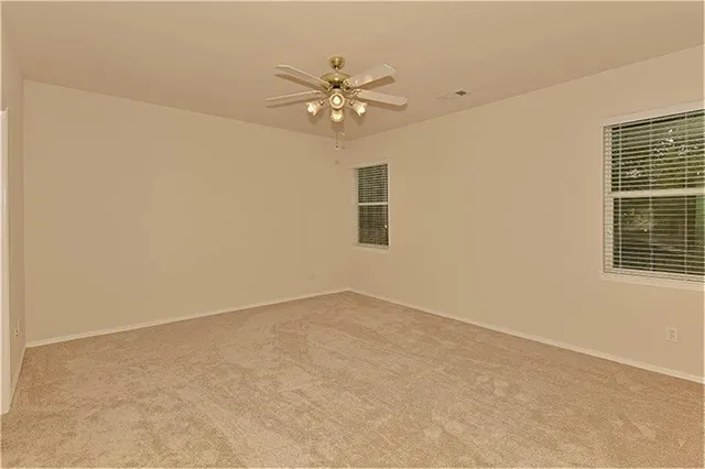 a view of a livingroom with a ceiling fan and window