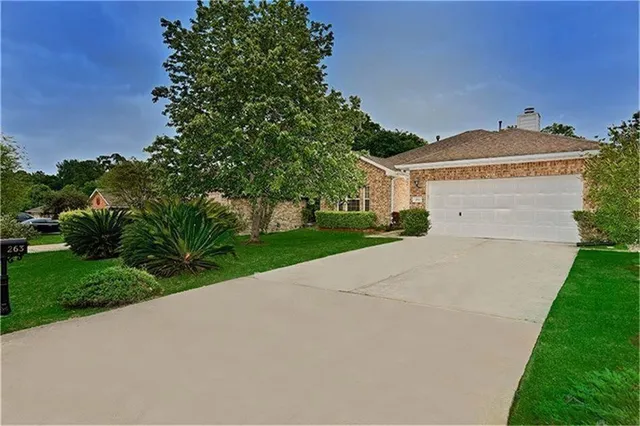 a front view of a house with a garden