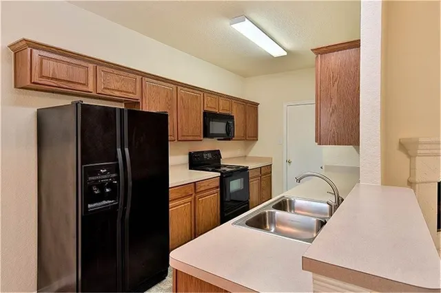 a kitchen with stainless steel appliances a refrigerator sink and microwave