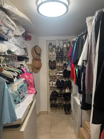 a view of walk in closet with clothes and shoes