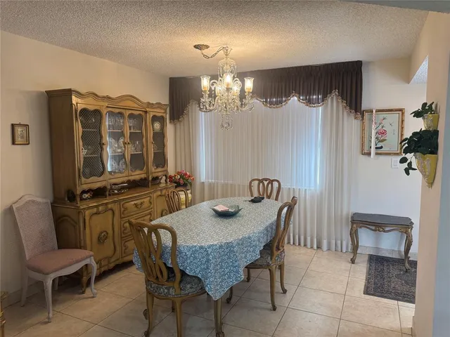 a dining room with furniture a chandelier and window