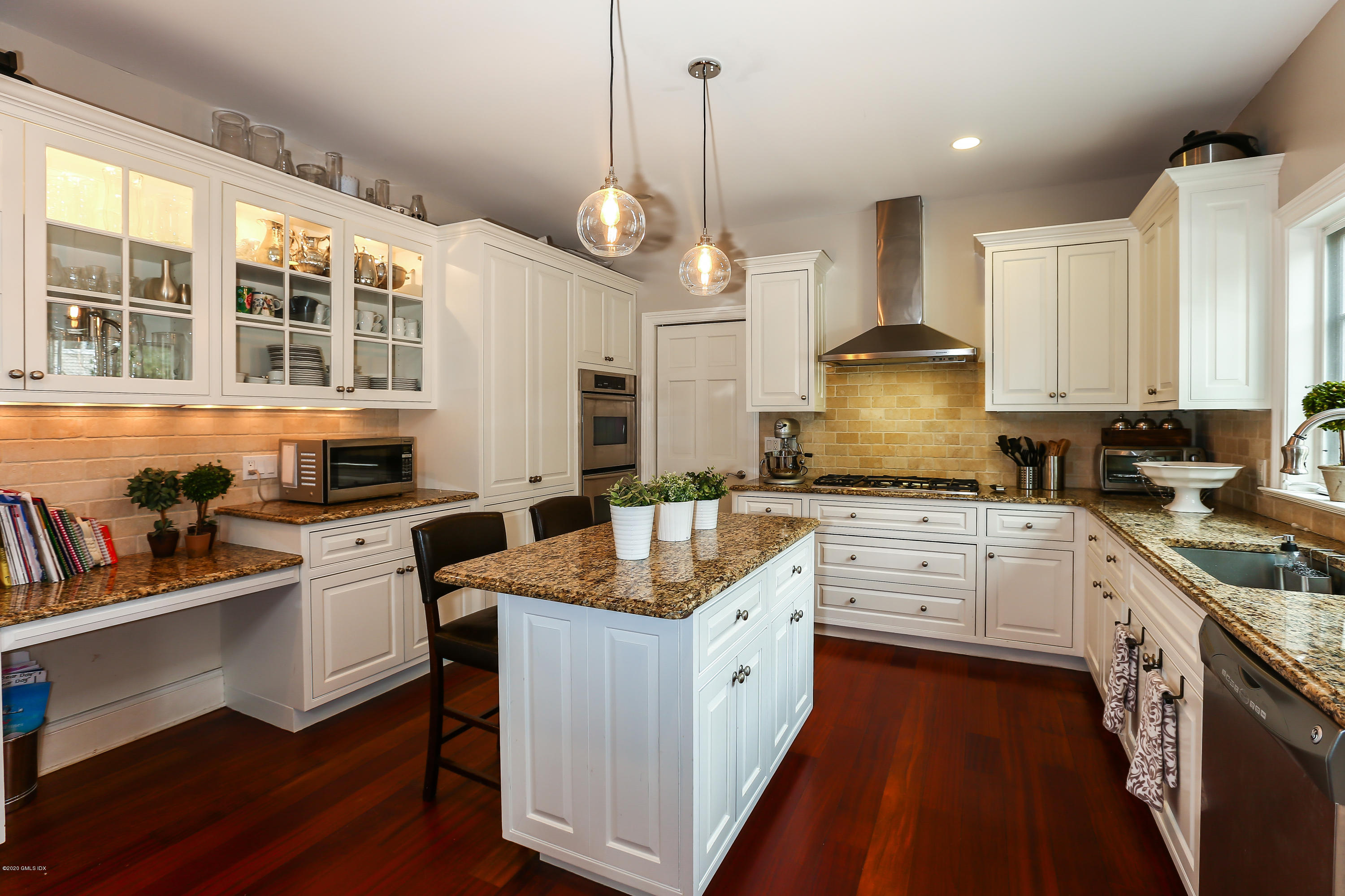 59 Riverside Lane Riverside, CT 06878 - Photo 5 of 21 a large kitchen with granite countertop a stove a sink a refrigerator and white cabinets with wooden floor