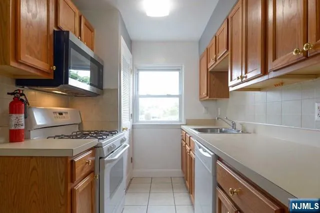 a kitchen with stainless steel appliances a stove a sink and a microwave