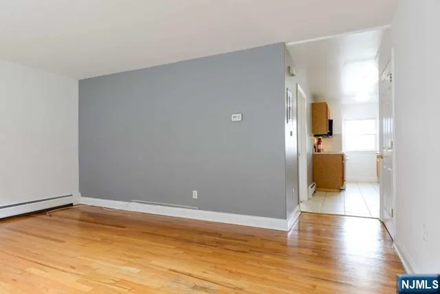 a view of a room with wooden floor and a bathroom
