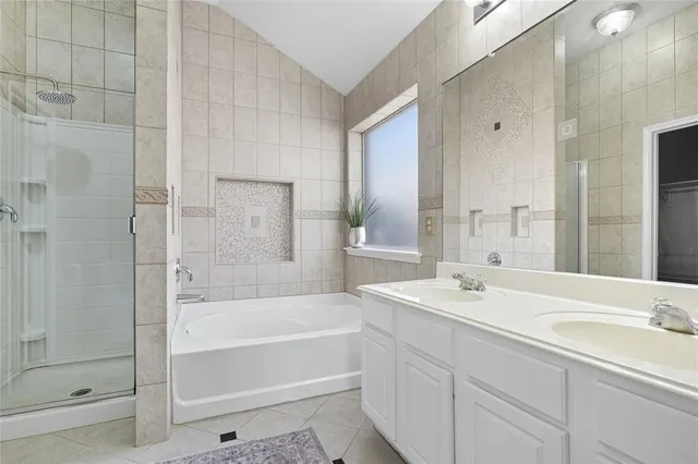 a bathroom with a bathtub shower sink vanity and mirror