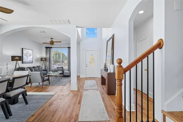 a view of a hallway with wooden floor and furniture