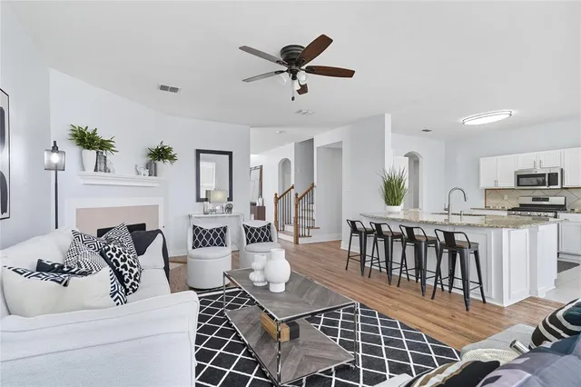 a living room with furniture a fireplace and a chandelier