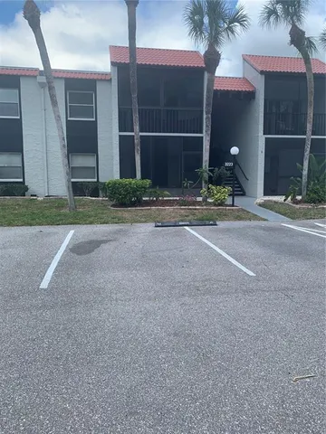 a view of a house with backyard and parking space