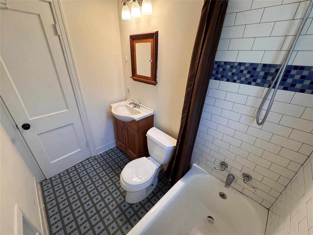 2547 Sharon Street Dallas, TX 75211 - Photo 12 of 22 a bathroom with a sink a toilet and shower