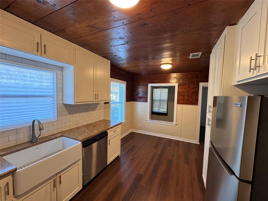 2547 Sharon Street Dallas, TX 75211 - Photo 5 of 22 a kitchen with stainless steel appliances granite countertop a refrigerator a sink and wooden cabinets