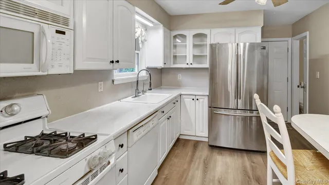 a kitchen with a table chairs refrigerator and cabinets