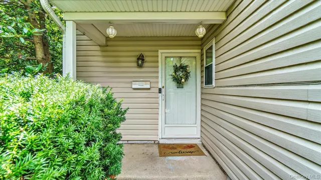 a view of house with wooden stairs and potted plants