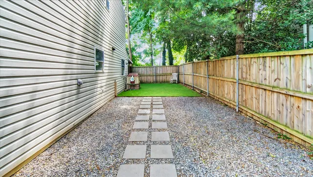 a view of a deck with table and chairs with wooden floor and roof with a garden view