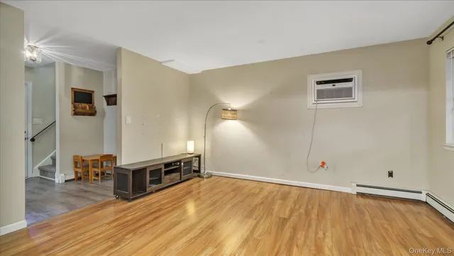 a view of a hallway with wooden floor and a kitchen