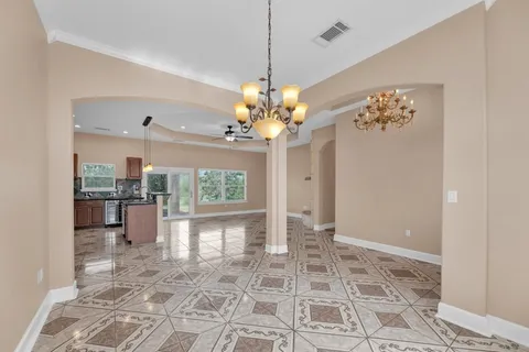 an empty room with a fireplace and chandelier