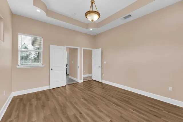 a kitchen with stainless steel appliances granite countertop a refrigerator a oven a stove and a sink with wooden floors