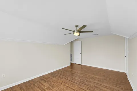 a view of a big room with wooden floor and windows