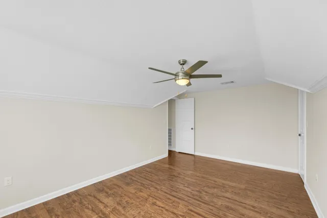 a view of a big room with wooden floor and windows