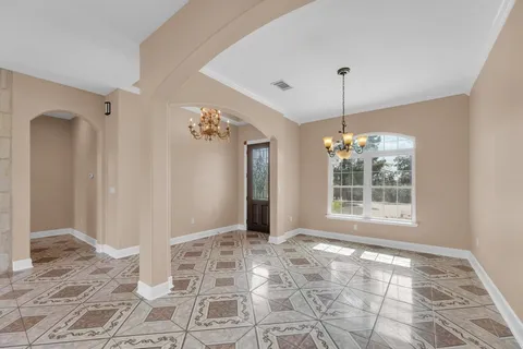 a view of a big room with windows and chandelier