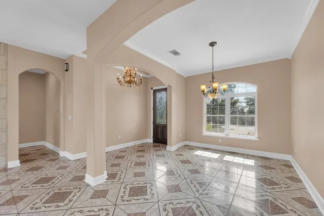 a view of a big room with windows and chandelier