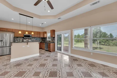 a large white kitchen with a sink stainless steel appliances and cabinets