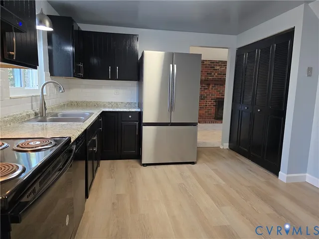 a kitchen with granite countertop a refrigerator a stove and a sink