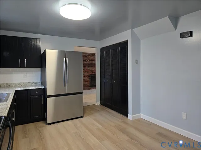 a kitchen with granite countertop a refrigerator and a sink