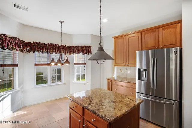 a kitchen with stainless steel appliances granite countertop a refrigerator a stove and a sink