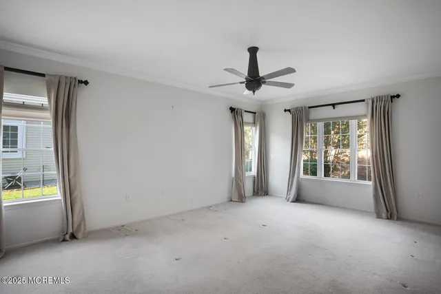 a view of an empty room with a window and kitchen view