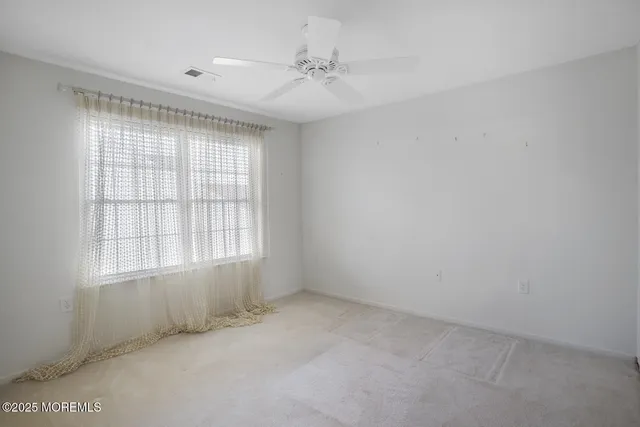 an empty room with a window and a ceiling fan