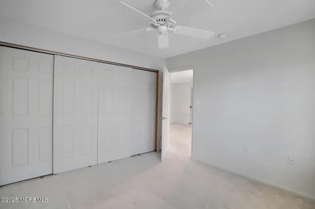 an empty room with a ceiling fan and a window