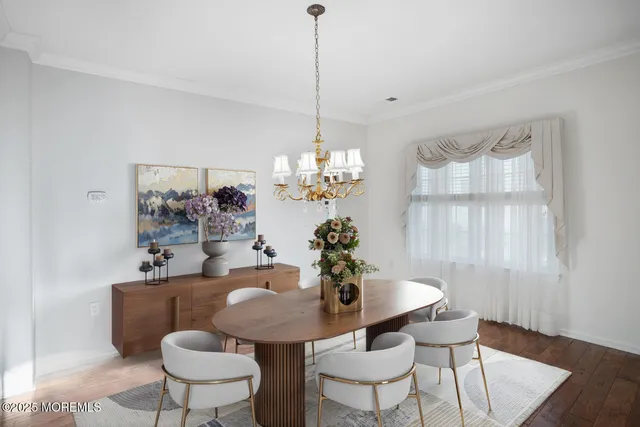 a dining room with furniture a chandelier and wooden floor