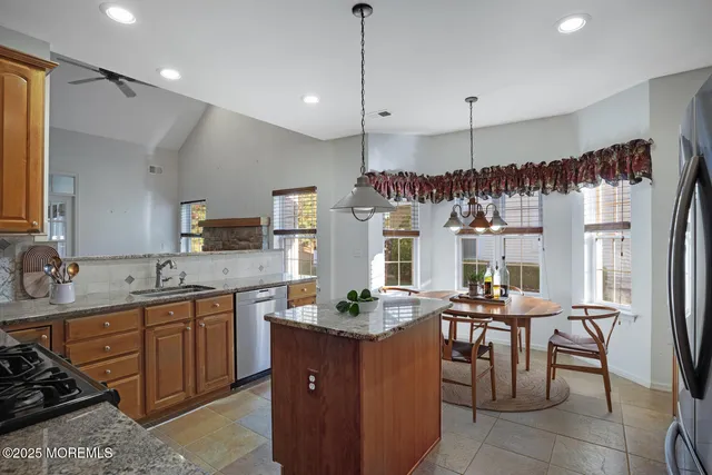 a kitchen with granite countertop a sink cabinets and stainless steel appliances