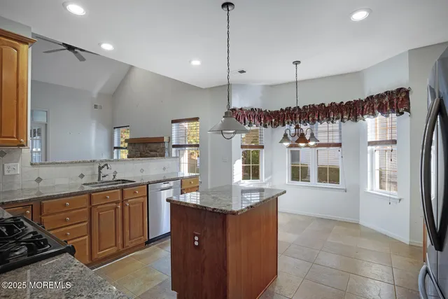 a kitchen with stainless steel appliances granite countertop a sink and a refrigerator