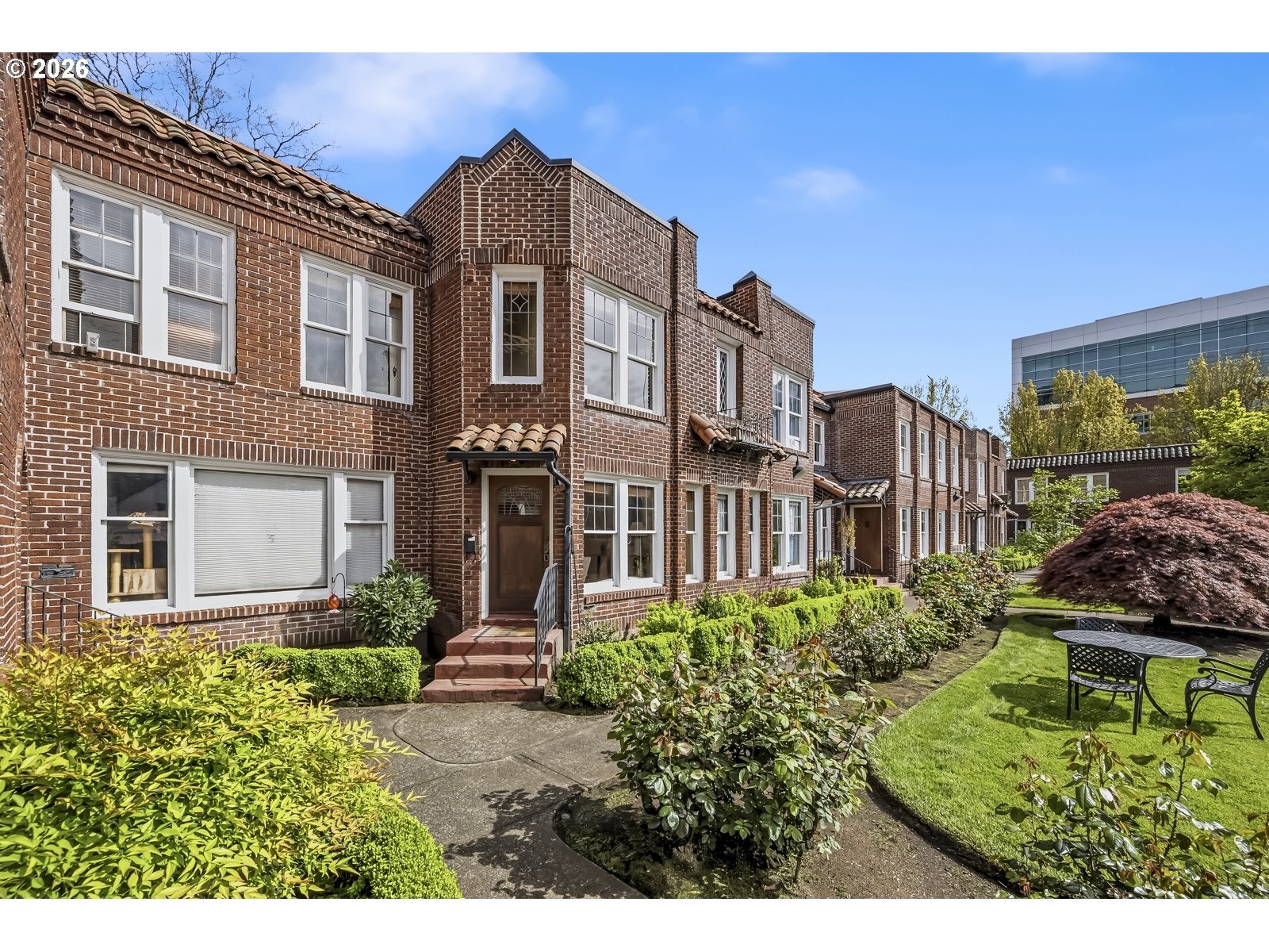 a view of a brick building next to a yard