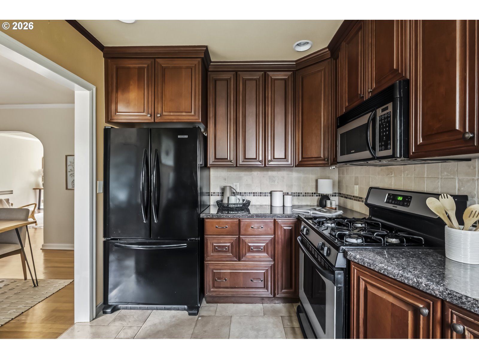 4353 Northeast Halsey Street, Unit 4 Portland, OR 97213 - Photo 5 of 24 a kitchen with granite countertop a refrigerator stove and microwave