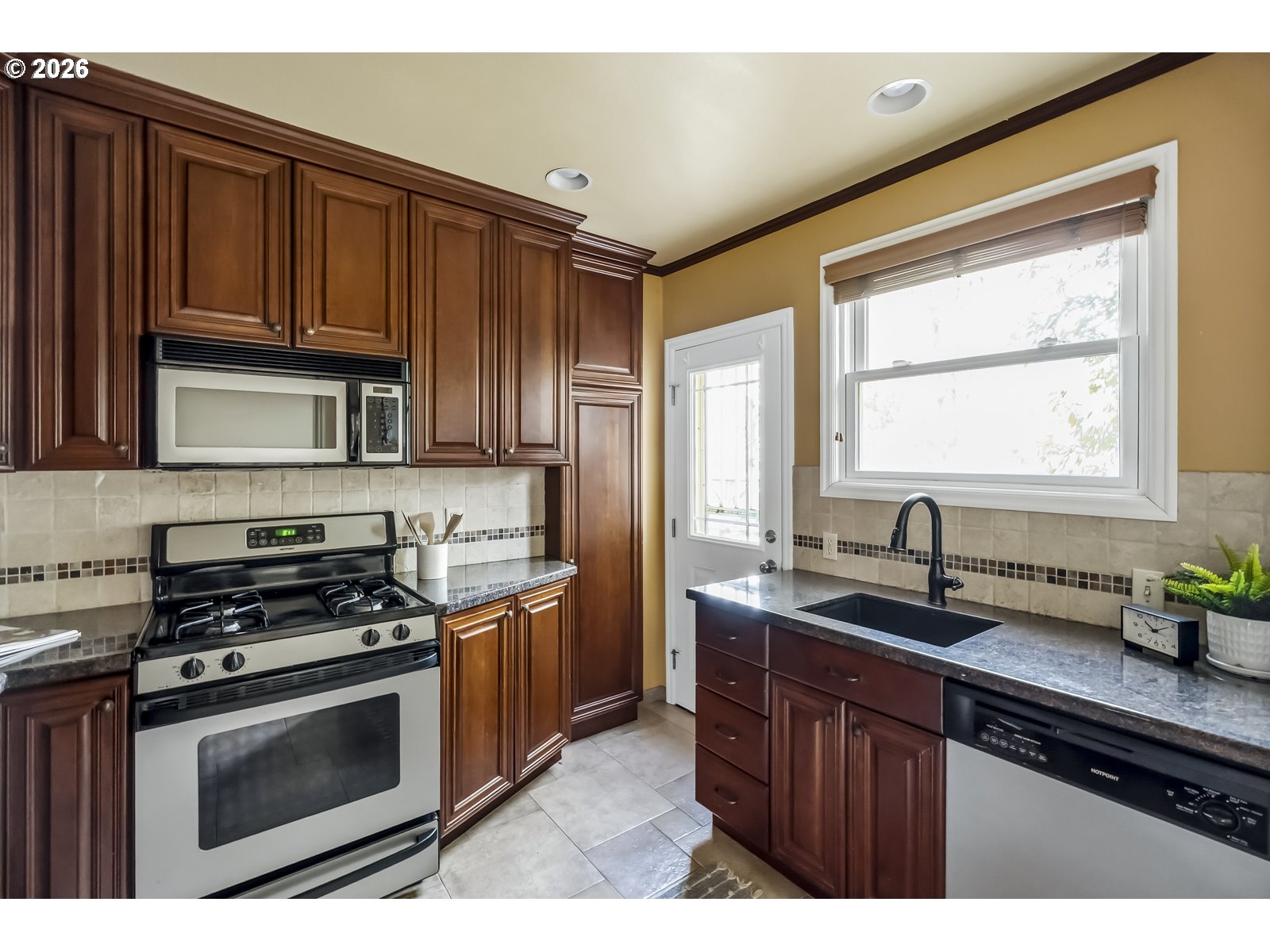 4353 Northeast Halsey Street, Unit 4 Portland, OR 97213 - Photo 6 of 24 a kitchen with stainless steel appliances granite countertop a sink stove and microwave
