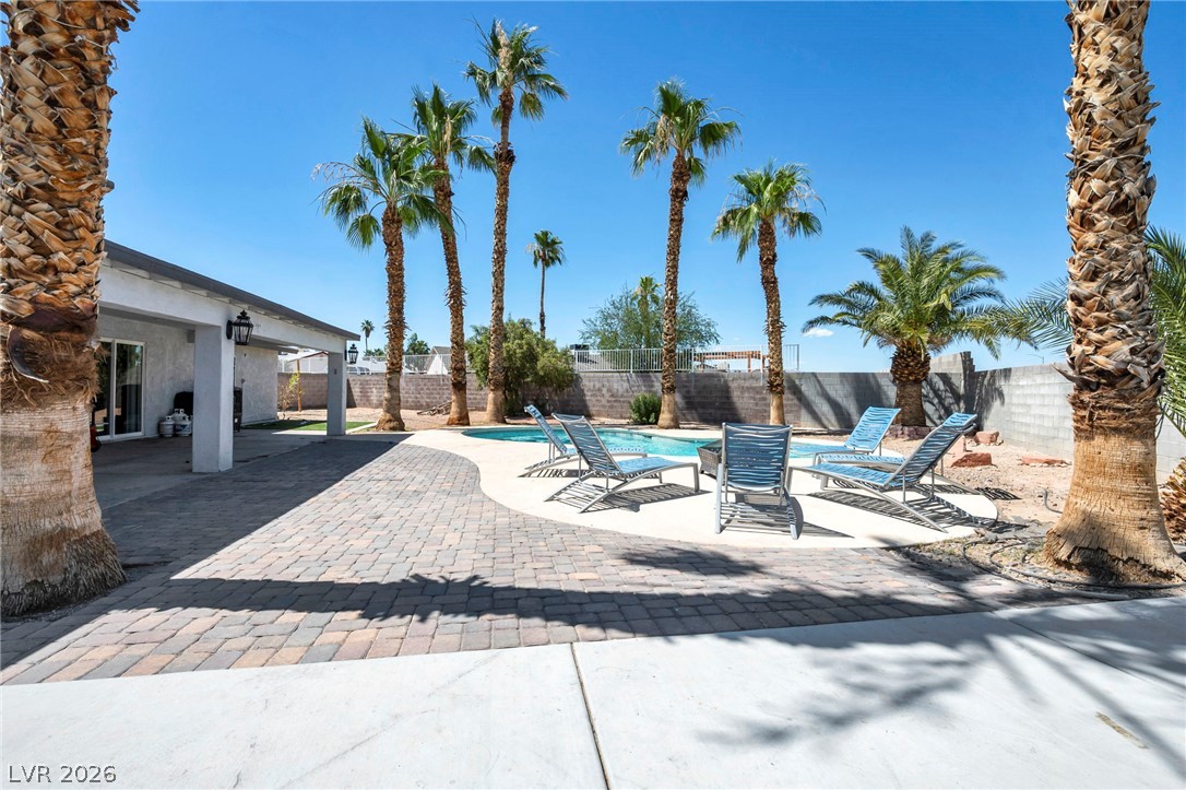 5882 Rio Tinto Way Las Vegas, NV 89110 - Photo 45 of 56 An inviting pool area with a paver patio and mature palm trees offers a tranquil desert escape.