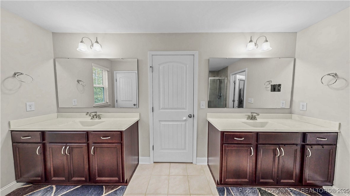 493 Timber Skip Drive Spring Lake, NC 28390 - Photo 18 of 33 a bathroom with a granite countertop double vanity sink and a mirror