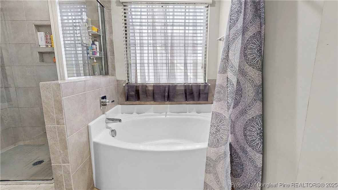 493 Timber Skip Drive Spring Lake, NC 28390 - Photo 20 of 33 a bathroom with shower and bathtub