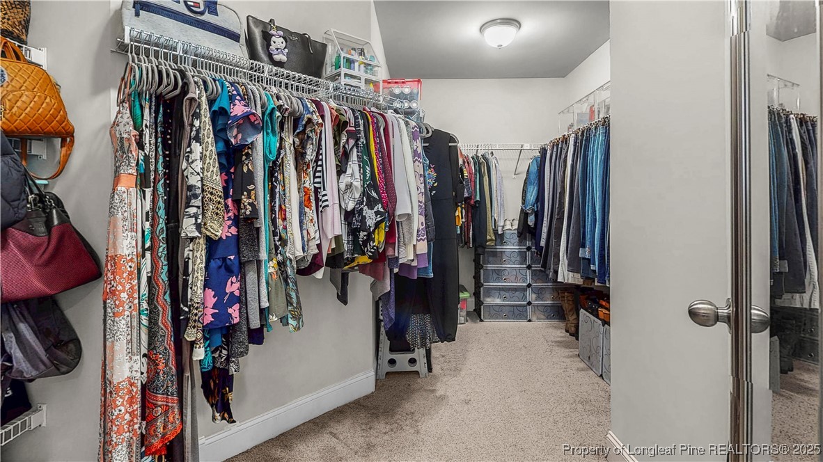 493 Timber Skip Drive Spring Lake, NC 28390 - Photo 21 of 33 a view of walk in closet with clothes