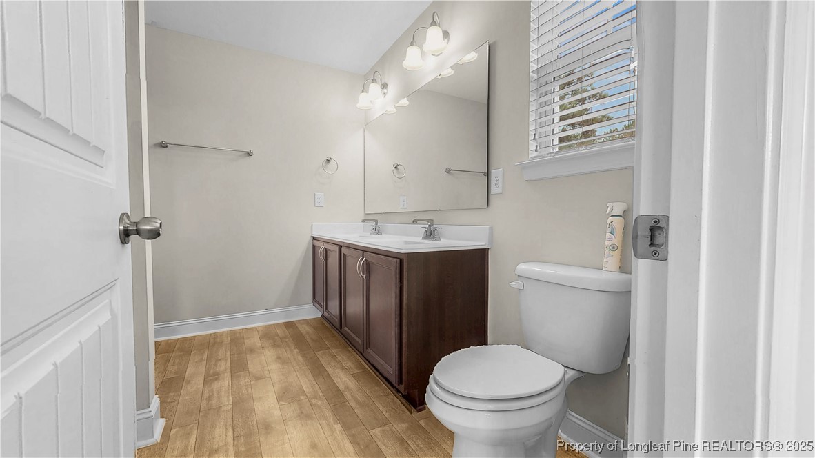 493 Timber Skip Drive Spring Lake, NC 28390 - Photo 23 of 33 a bathroom with a toilet sink and a mirror