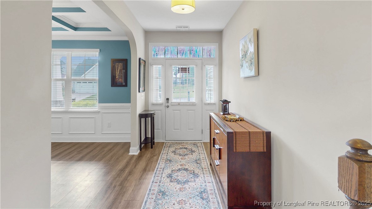 493 Timber Skip Drive Spring Lake, NC 28390 - Photo 4 of 33 a view of a hallway with wooden floor and a living room