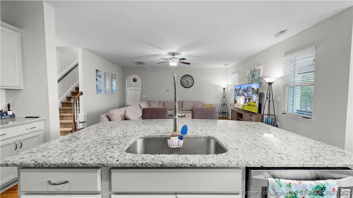 493 Timber Skip Drive Spring Lake, NC 28390 - Photo 9 of 33 a kitchen with kitchen island a sink granite counter tops and a view of living room