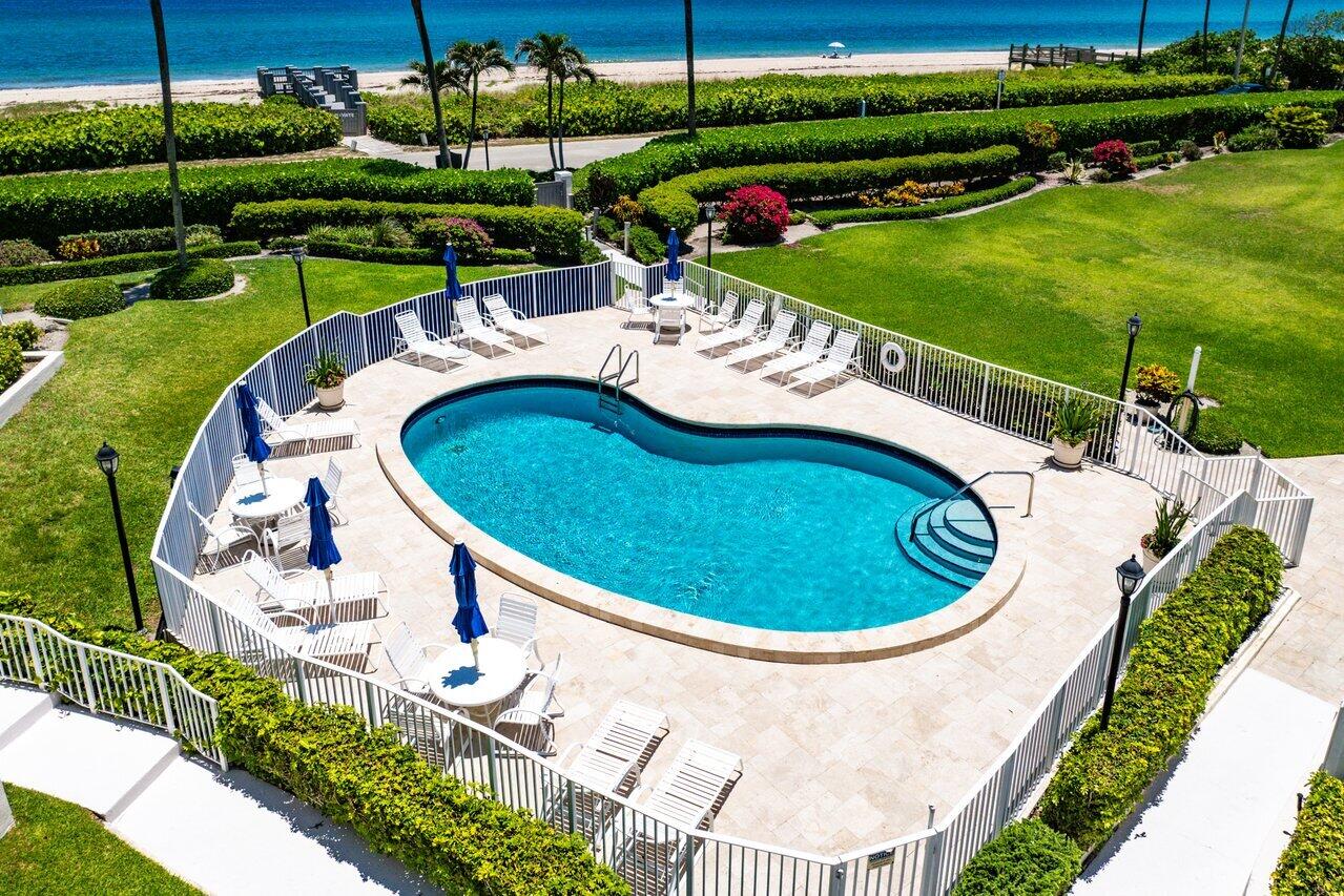 5900 Old Ocean Boulevard, Unit C6 Ocean Ridge, FL 33435 - Photo 3 of 21 a view of a swimming pool with lawn chairs and plants