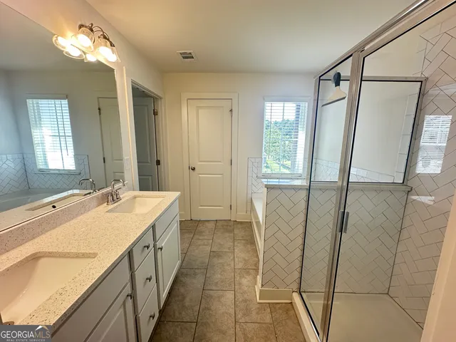 a bathroom with a tub sink and mirror