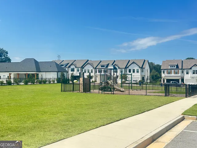 a view of a big house with a big yard and large trees