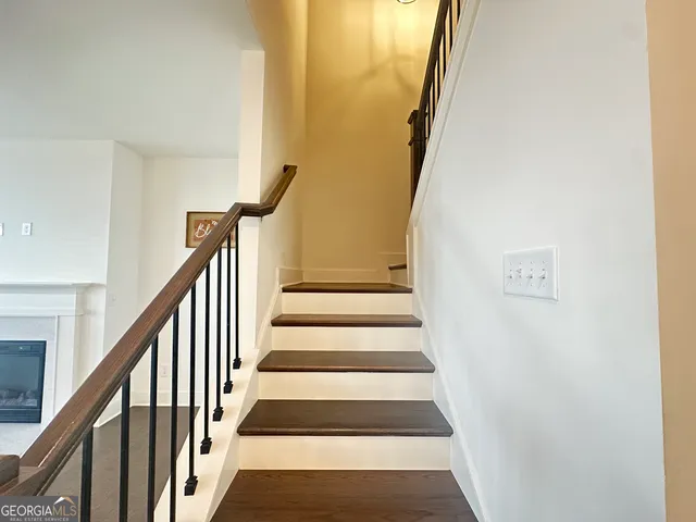 a view of staircase with railing and white walls